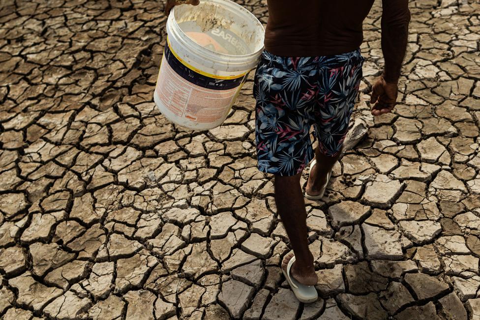 Fisherman and trader Raimundo Silva do Carmo, 67, fetches water from a well, Lago do Puraquequara lake, Manaus, Brazil