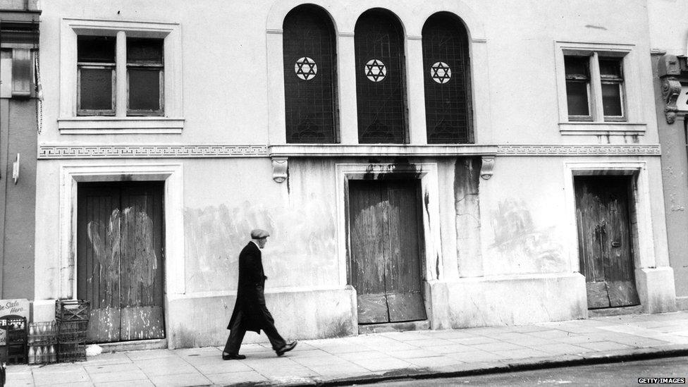 Man walking in front of a synagogue