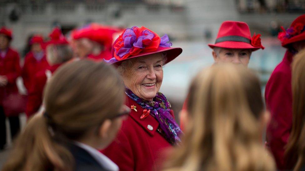 Women from the Ruislip Red Hatters chat to girls from Eltham Hill School after observing a two minute silence