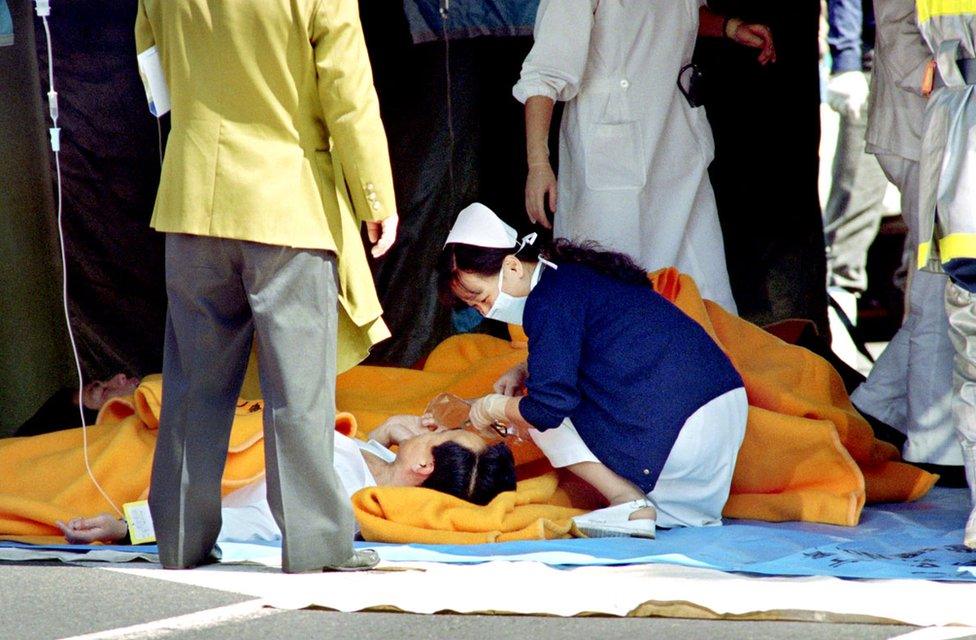 A commuter is treated by an emergency medical team at a make-shift shelter before being transported to hospital.