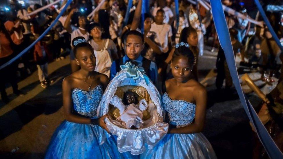 Afro-Colombians hold a basket with "Nino Dios" (God Child) inside in Quinamayo, department of Valle del Cauca, Colombia, on February 18, 2018.