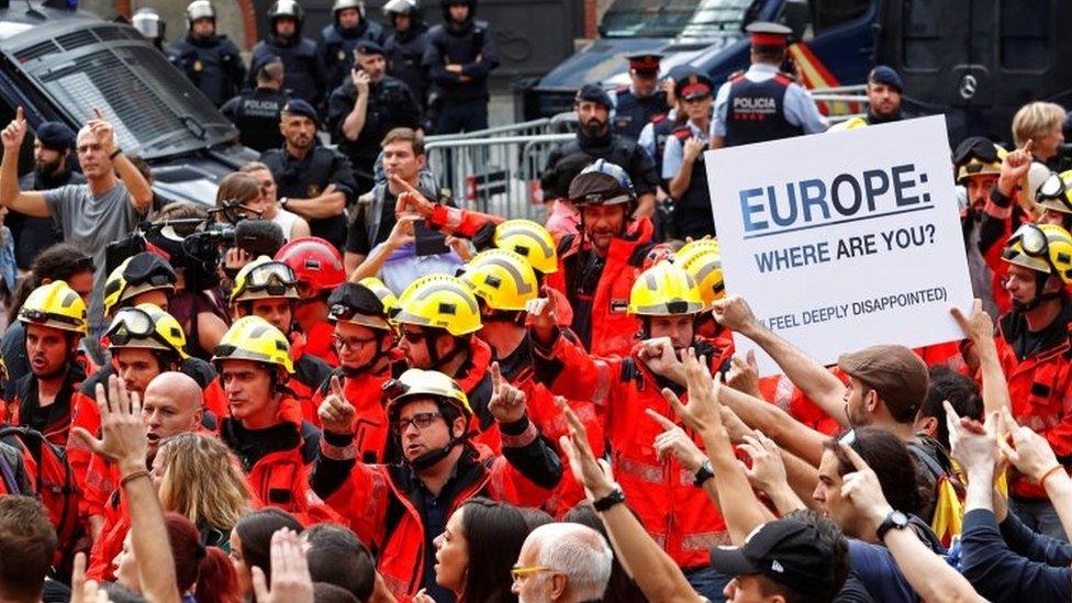 Fire fighters hold up their hands during a demonstration called to protest against police actions during the banned independence referendum in Barcelona (03 October 2017)