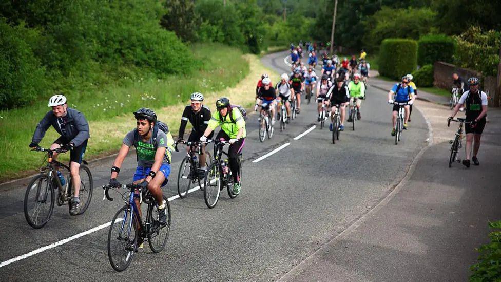 A group of people cycling on a road.