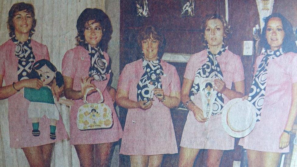 The 1971 translators, holding items of tournament merchandising