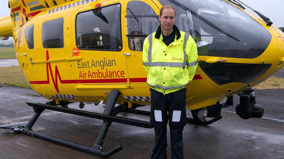 Prince William in front of an East Anglian Air Ambulance helicopter