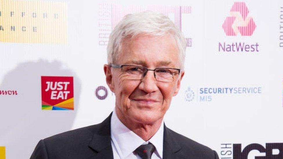 Paul O'Grady smiling while wearing a suit at an event