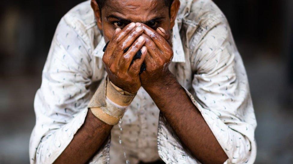 A scavenger quenches his thirst with water from a roadside tap amid rising temperatures in New Delhi on May 27, 2020. - India is wilting under a heatwave, with the temperature in places reaching 50 degrees Celsius (122 degrees Fahrenheit) and the capital enduring its hottest May day in nearly two decades.