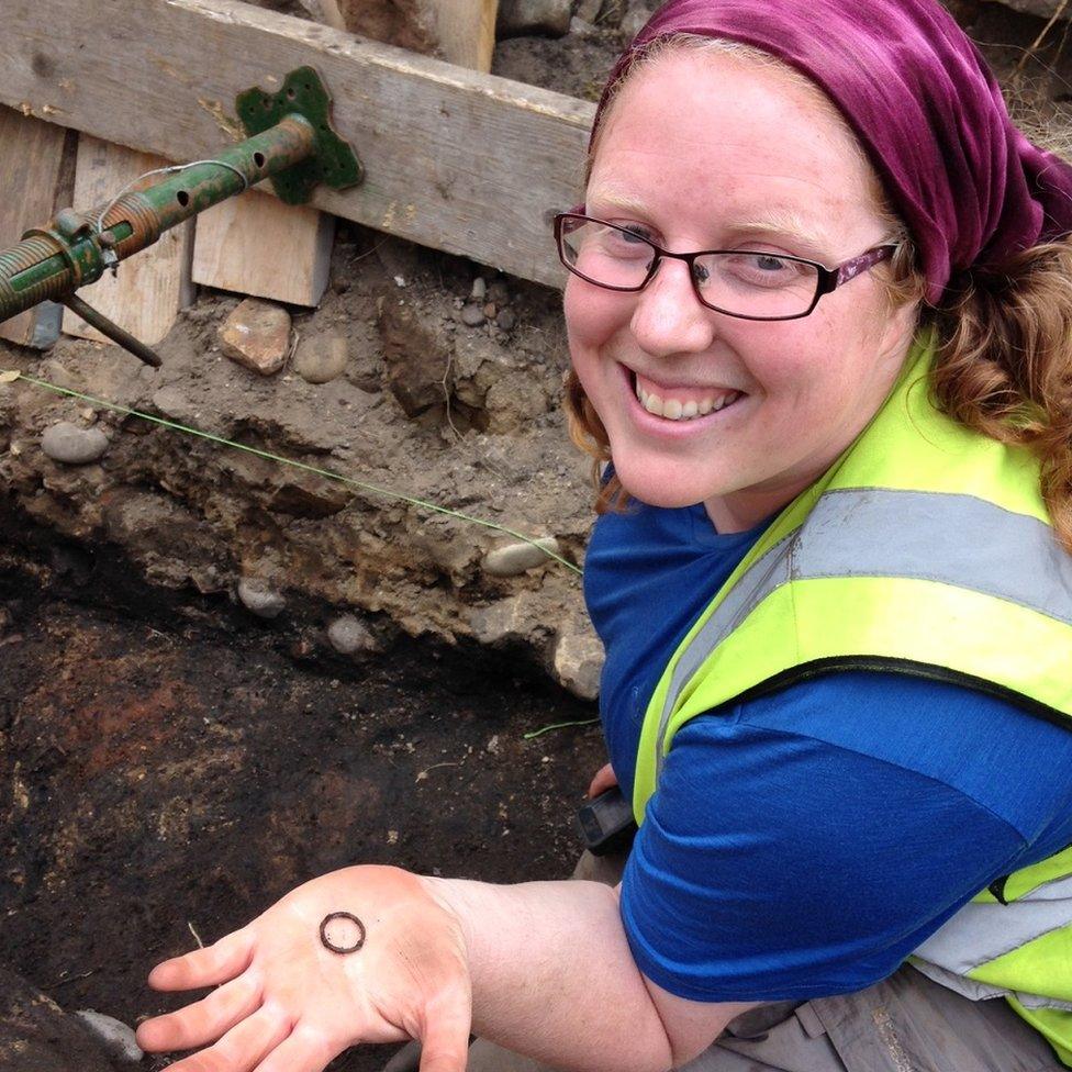 Cathy MacIver of AOC Archaeology with a bronze ring from the excavations