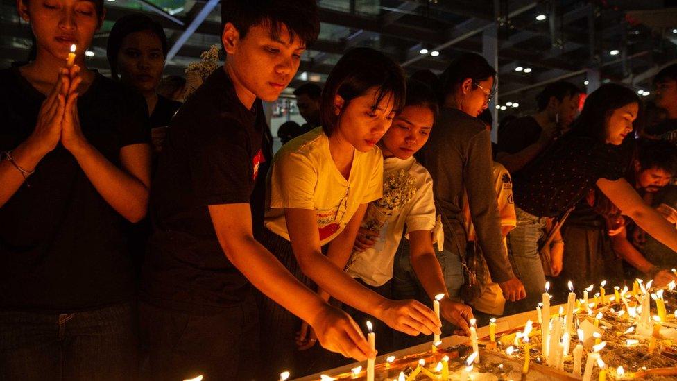 Thai mourners lighting candles