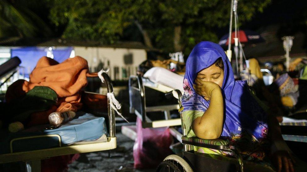 A survivor rests as she gets medical treatment outside a military hospital in Palu, Central Sulawesi, Indonesia, 29 September 2018.