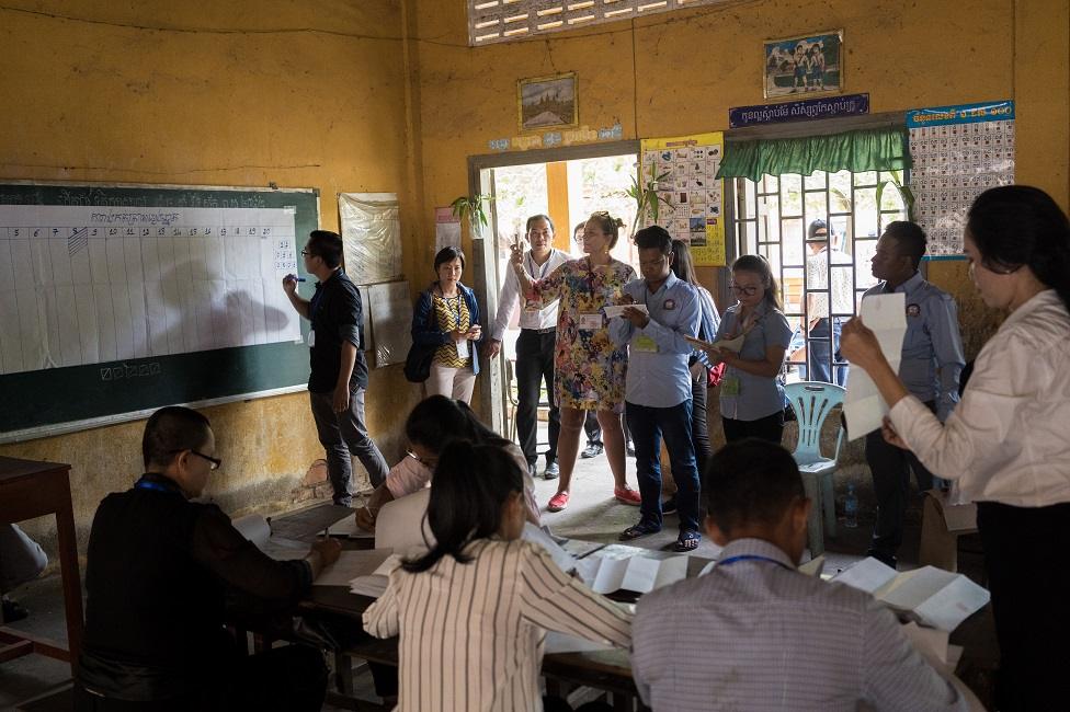 People watch as calculations are made on a black board