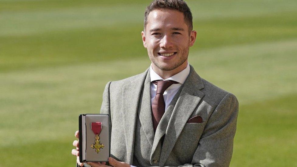 Alfie Hewett holding an OBE medal