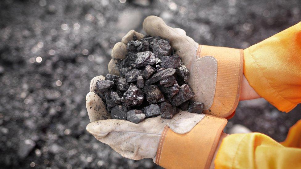 Coal worker with handful of coal