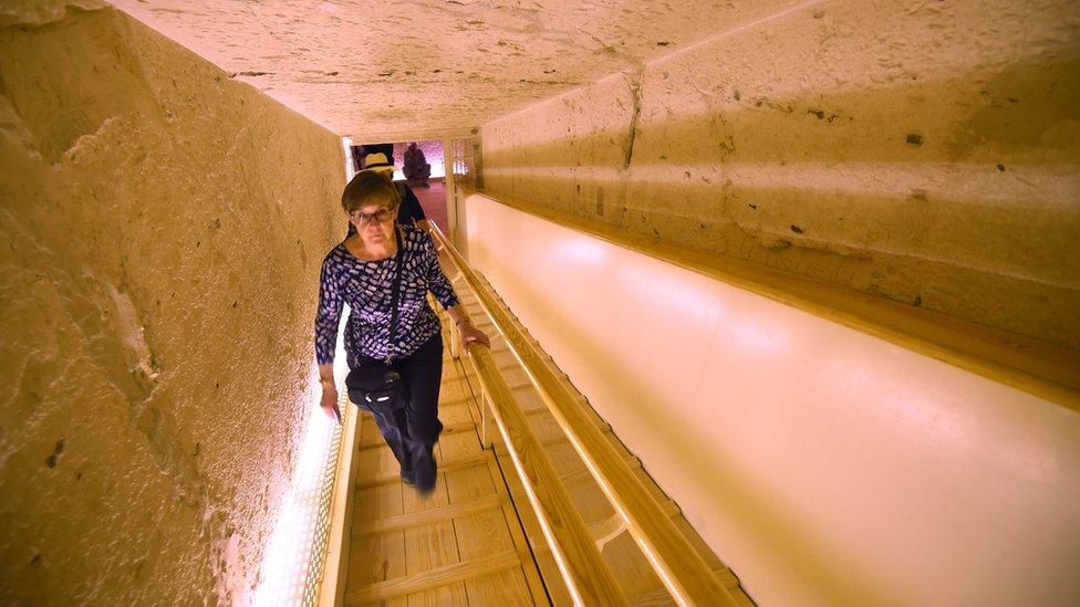 A woman ascends a tunnel leading out of the underground tomb of King Tutankhamun in the Valley of the Kings, Egypt (31 January 2019