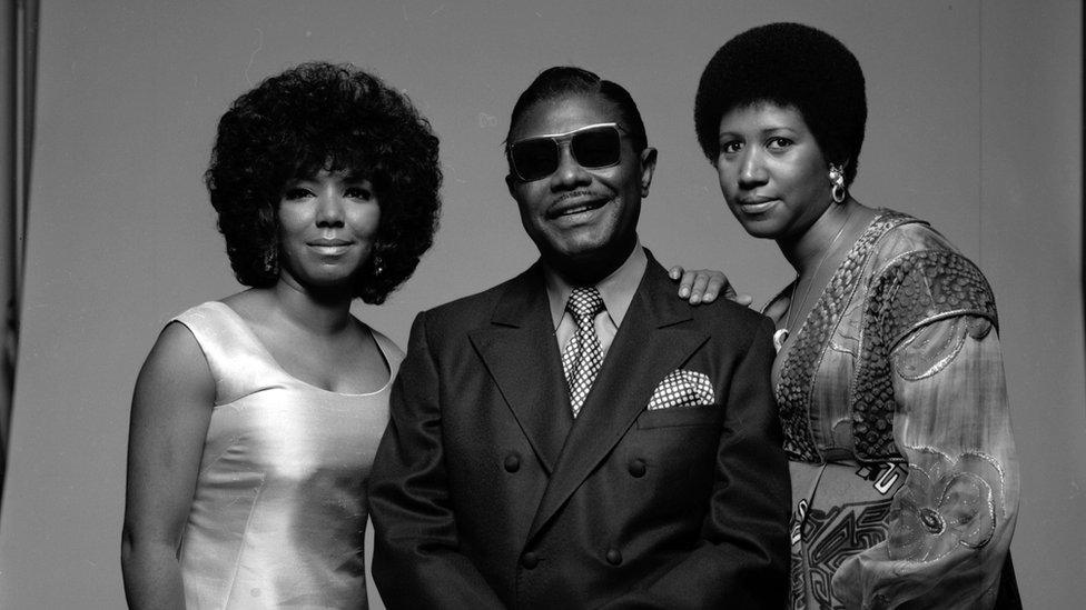 A black and white picture of Aretha Franklin, her father CL, and her sister, fellow singer Carolyn, taken in 1971.