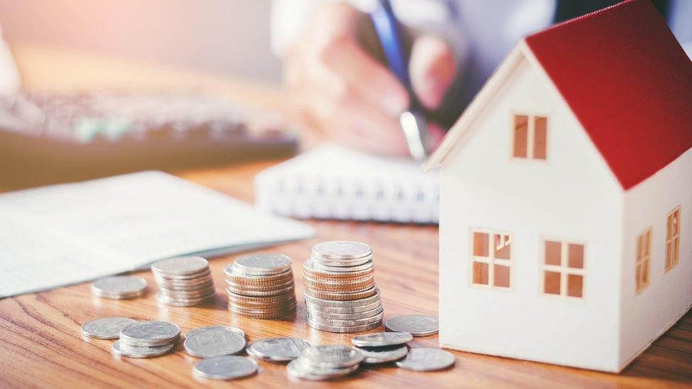 A model house and cash on the table