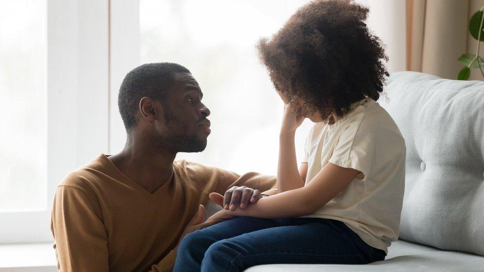 Young girl struggles with her mental health and is comforted by her father (stock image)