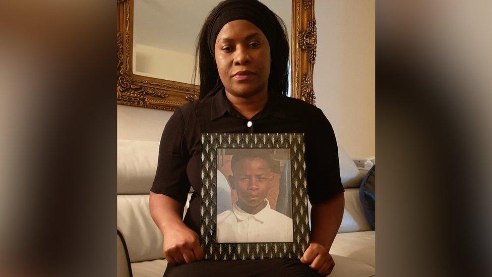 Alina Joseph holding a photo of her son