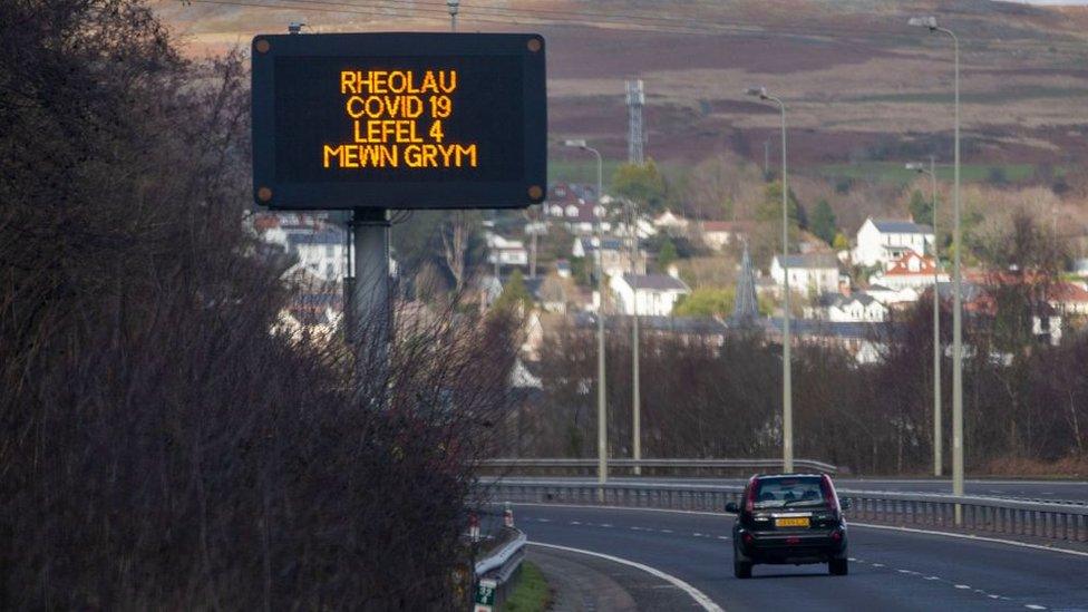 Merthyr road with sign in Welsh "Rheolau Covid 19 Lefel 4 Mewn Grym" - 'Covid 19 Rules - Level 4 in force'