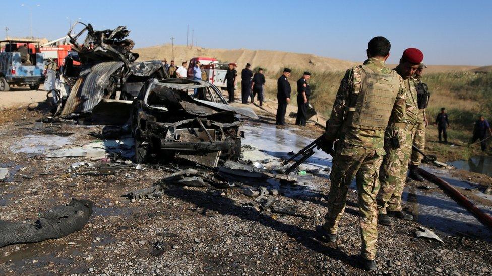 Iraqi forces inspect the site of a suicide bomb attack near Tikrit on 6 November 2016