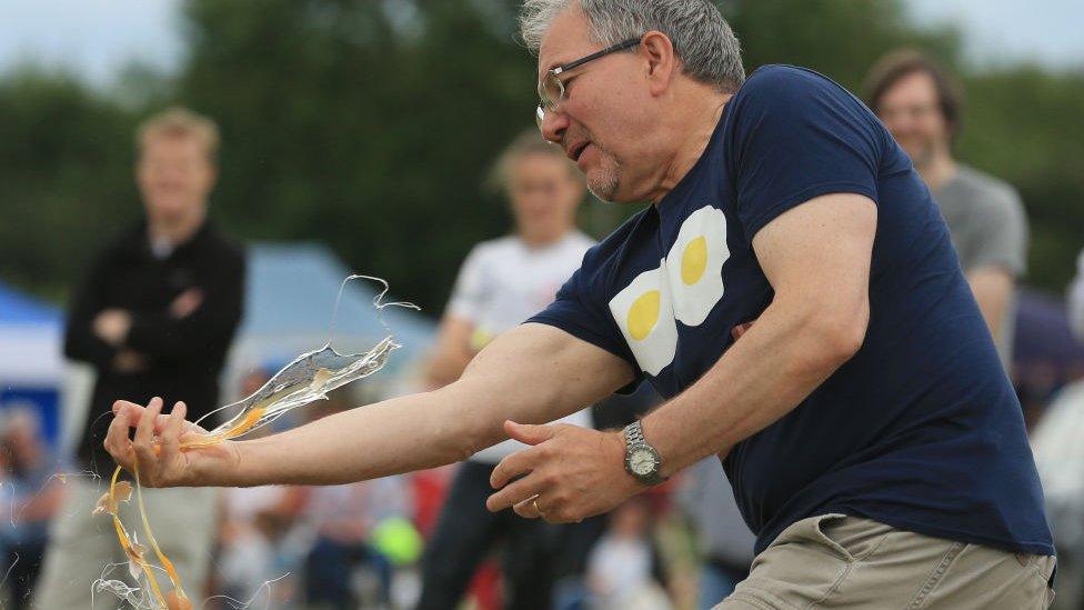 Competitor attempts to catch an egg