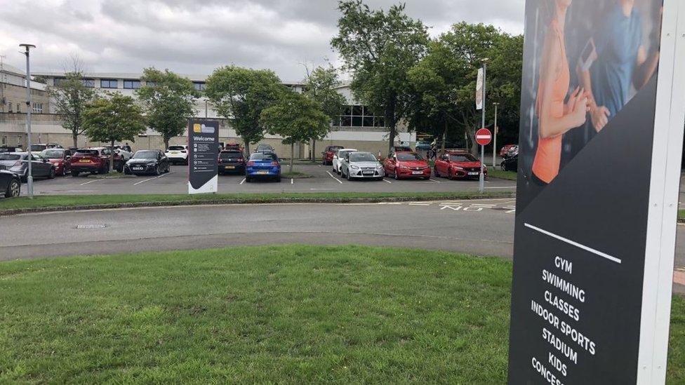 A car park with a sign in the foreground