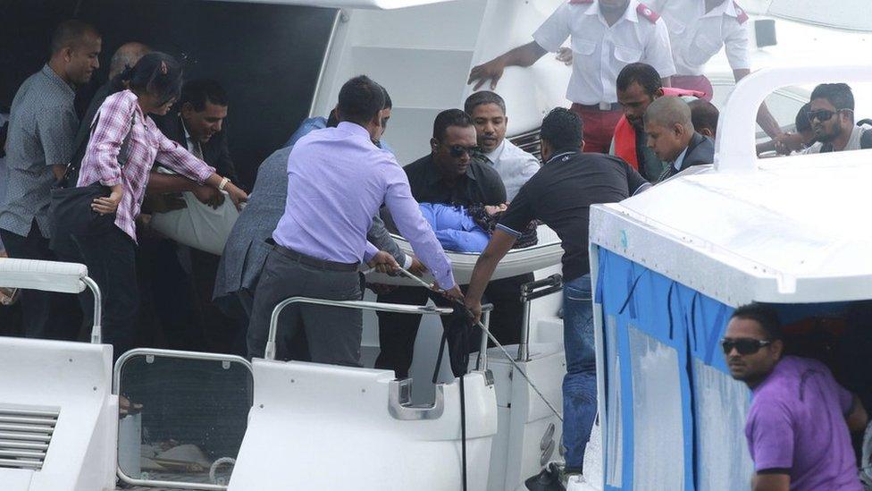 Officials carry an injured woman off the speed boat of Maldives President Abdullah Yameen (not pictured) after an explosion onboard, in Male, Maldives 28 September 2015