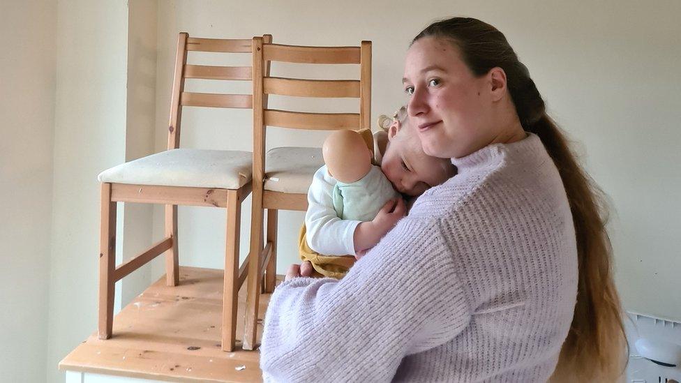 Rebecca holding daughter Hollie in their flood-hit home