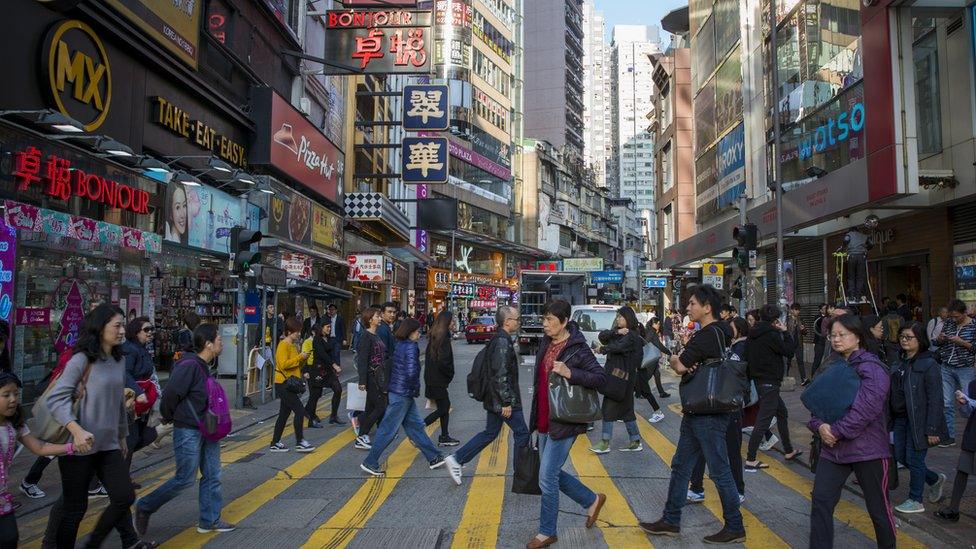 Pedestrians cross a street in Causeway Bay, Hong Kong