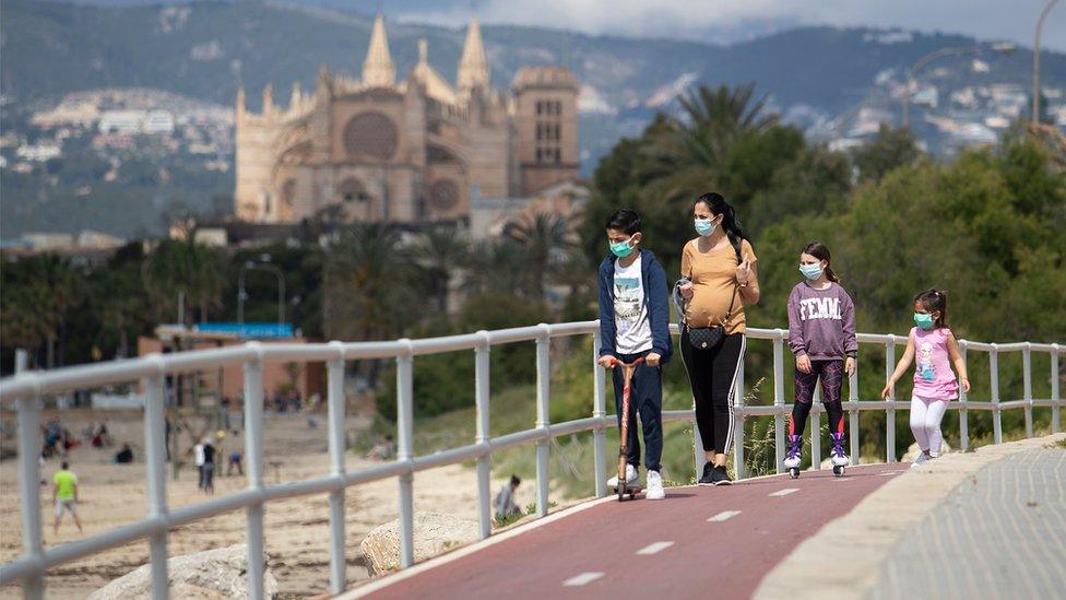 Children in face masks by a beach in Mallorca