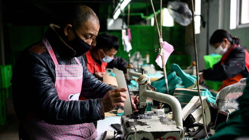 Workers wearing face masks as they make insoles at a factory