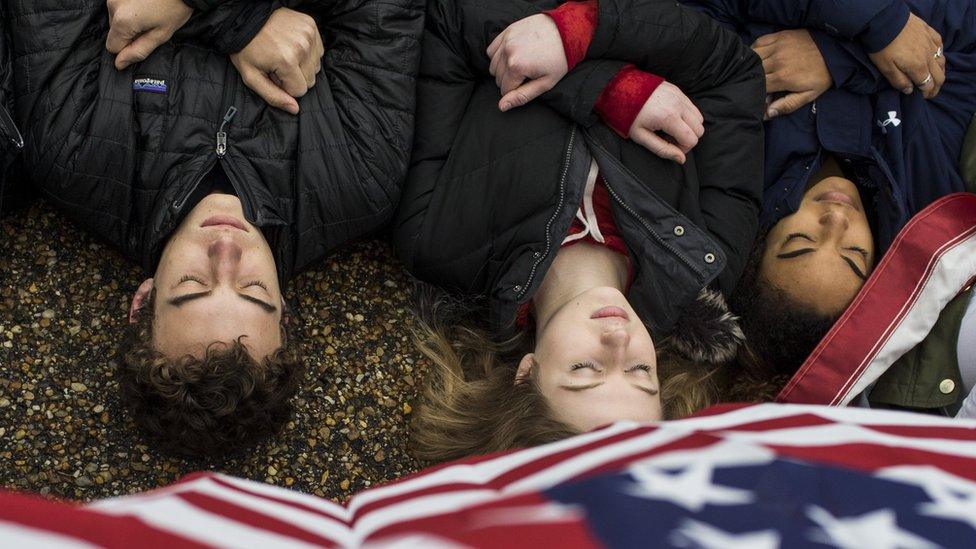 Demonstrators hold signs during a "lie-in" demonstration supporting gun control reform - 19 February 2018