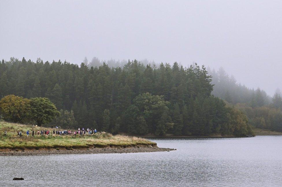 Runners next to foggy Kielder Water