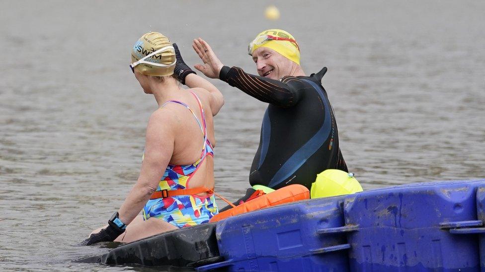 The couple high-five sitting on a pontoon