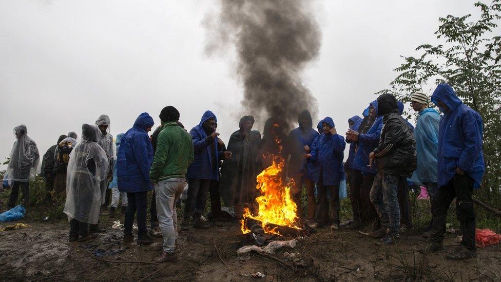 Migrants gather around a bonfire as they wait to cross the border with Croatia near the village of Berkasovo, Serbia, October 19, 2015.