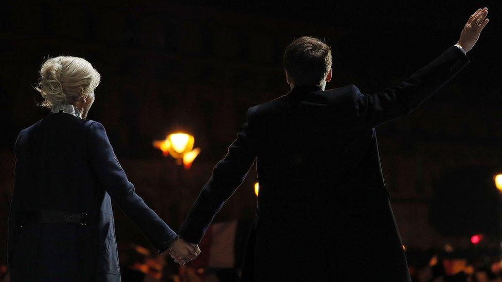 couple on stage, facing audience, silhouetted