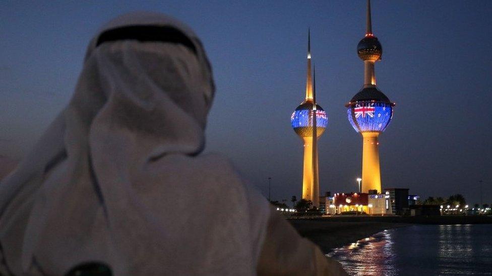 A man looking at the projection of New Zealand flag in Kuwait