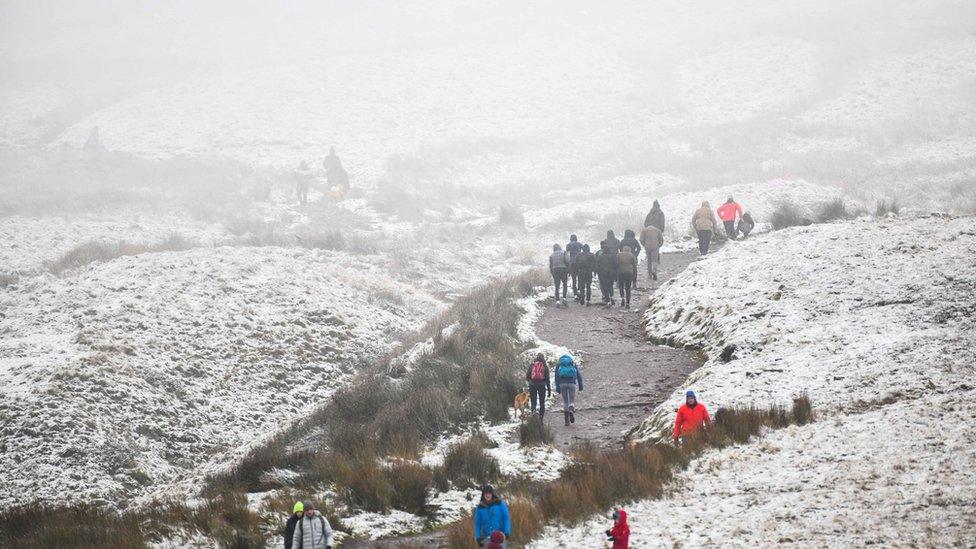 Cerddwyr yn yr eira ym Mhen-y-Fan