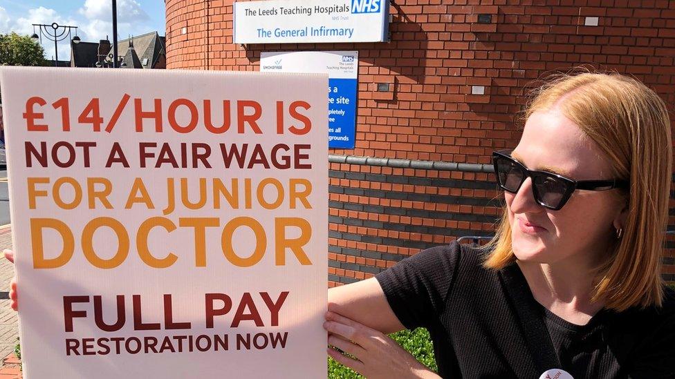 Junior doctor with sign on picket line