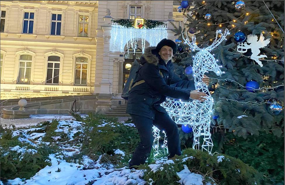 Andrii hugs a reindeer decoration outside the Lviv National Art Gallery