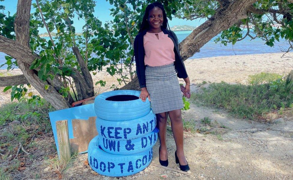 Kaiesha Joseph posing next to one of the bins crafted from discarded tyres