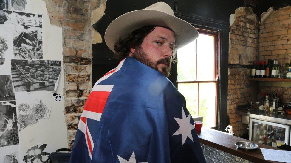 Betoota Advocate editor Clancy Overall drapes the Austrailan flag over his shoulders