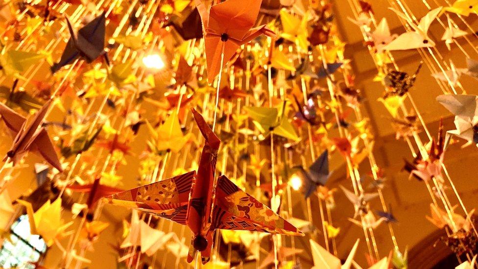 The cranes are suspended from the ceiling, to look like a flock