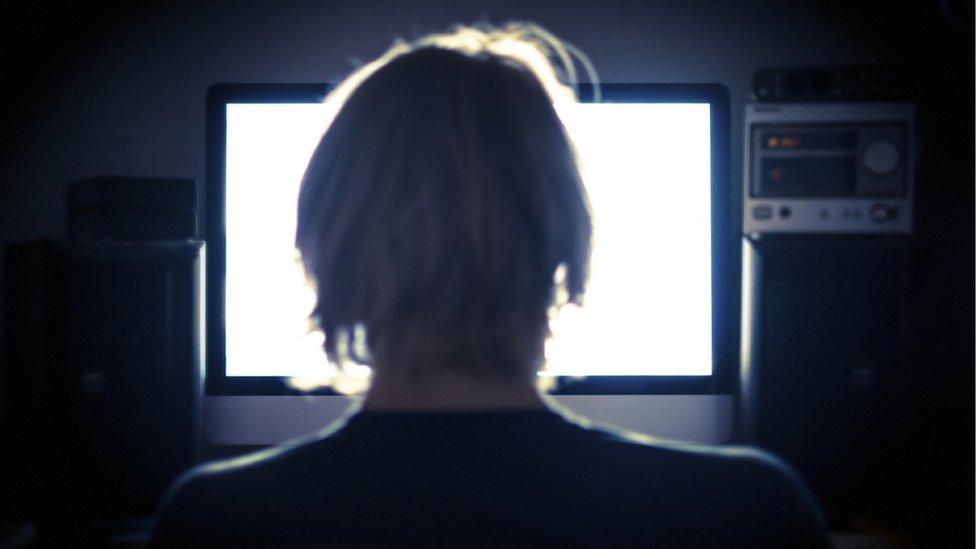 Anonymous back of head of man looking at computer