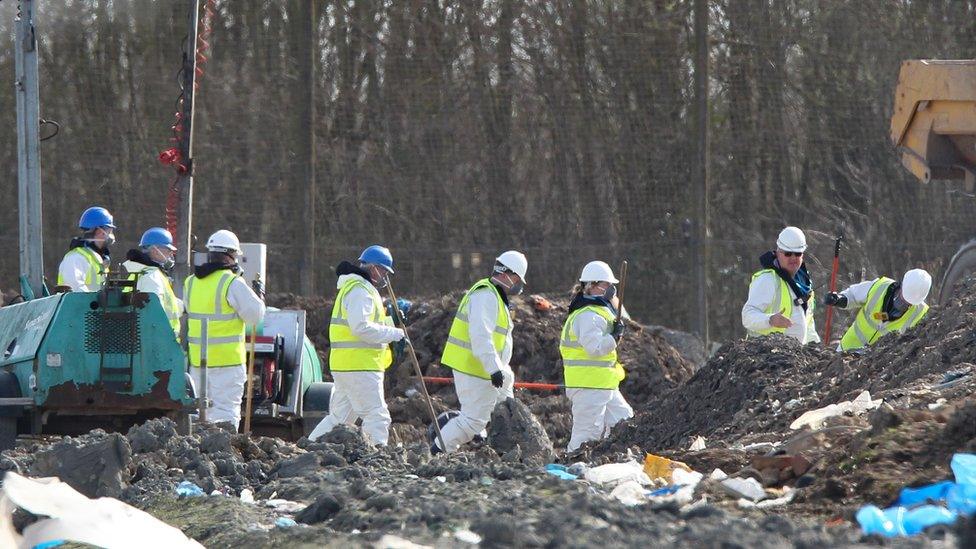 Police officers searching the landfill site