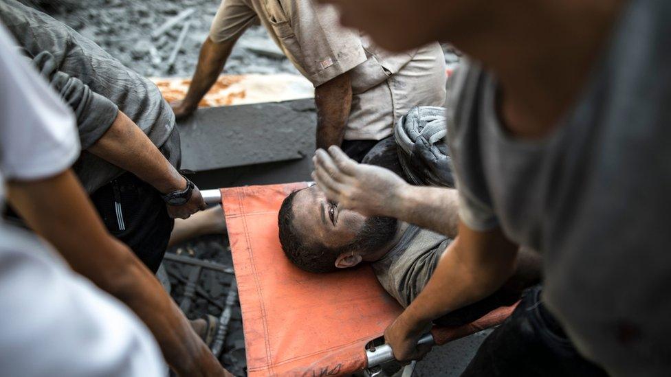 Palestinians carry a man injured in an Israeli strike in Khan Younis, southern Gaza Strip