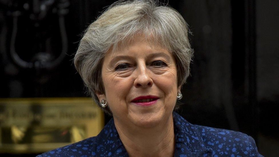 A picture of Prime Minister Theresa May looking at the camera and smiling.