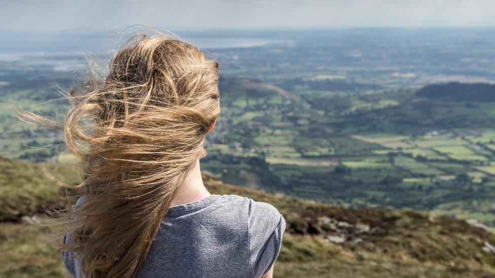 Girl looks out at Slieve Gullion in Northern Ireland