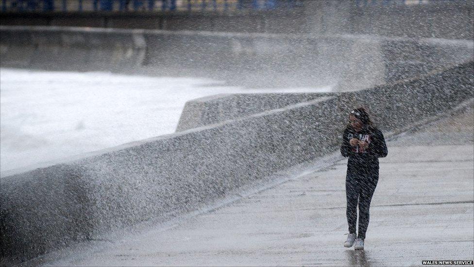 A woman being sprayed by the high tide