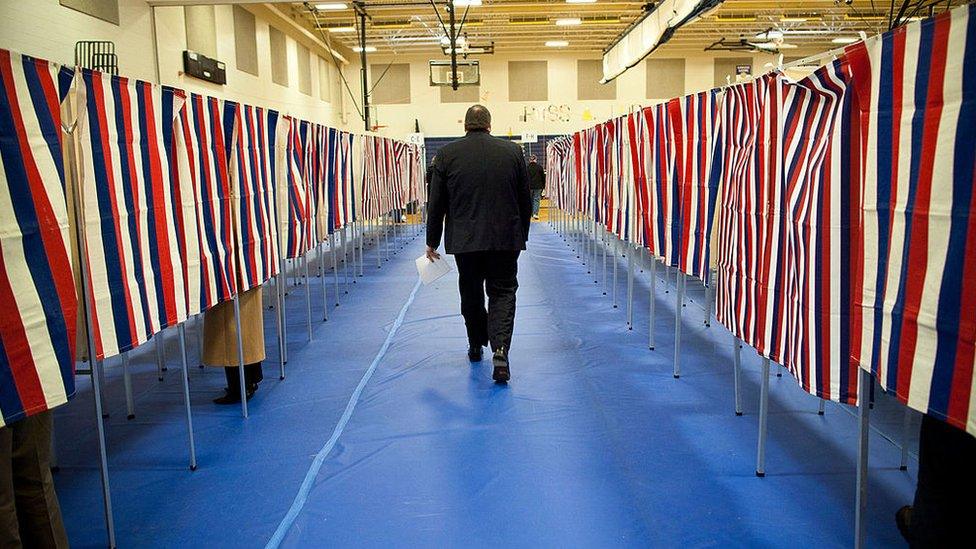 A man walks past voting booths in New Hampshire in 2020